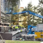 Equipo de operarios montando la plataforma del escenario en la Plaza de Lima, Madrid.