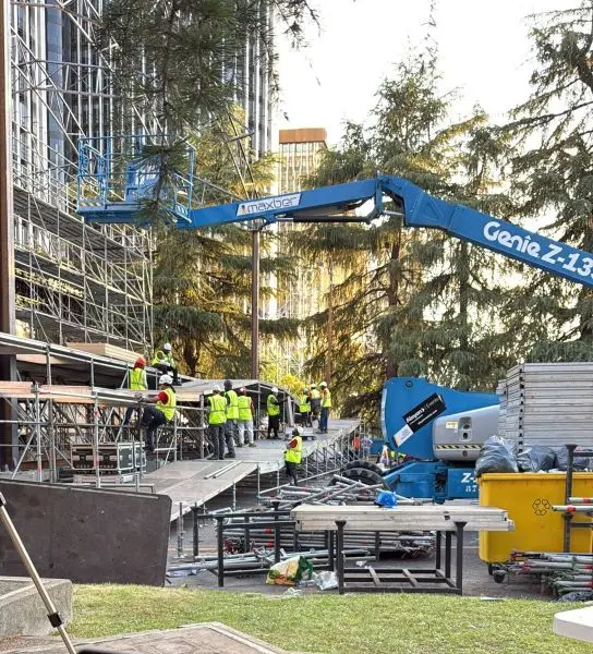 Equipo de operarios montando la plataforma del escenario en la Plaza de Lima, Madrid.